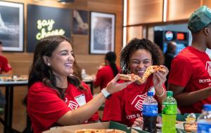 A group of students enjoying pizza.