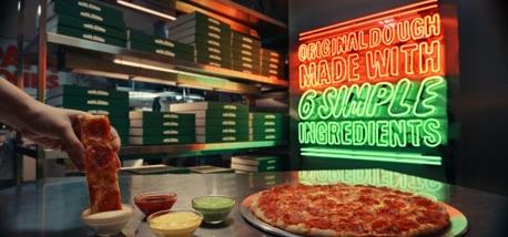 Pizza being dipped into garlic dip